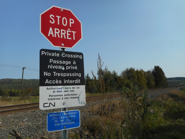 Stop sign at rail crossing by Salmon River Train Trestle