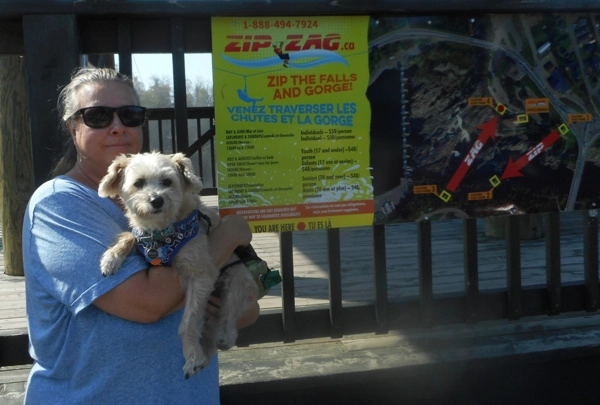 Woman and dog in front of Grand Falls zipline platform